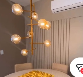 Sala de jantar com marcenaria planejada, mesa redonda e luminária suspensa